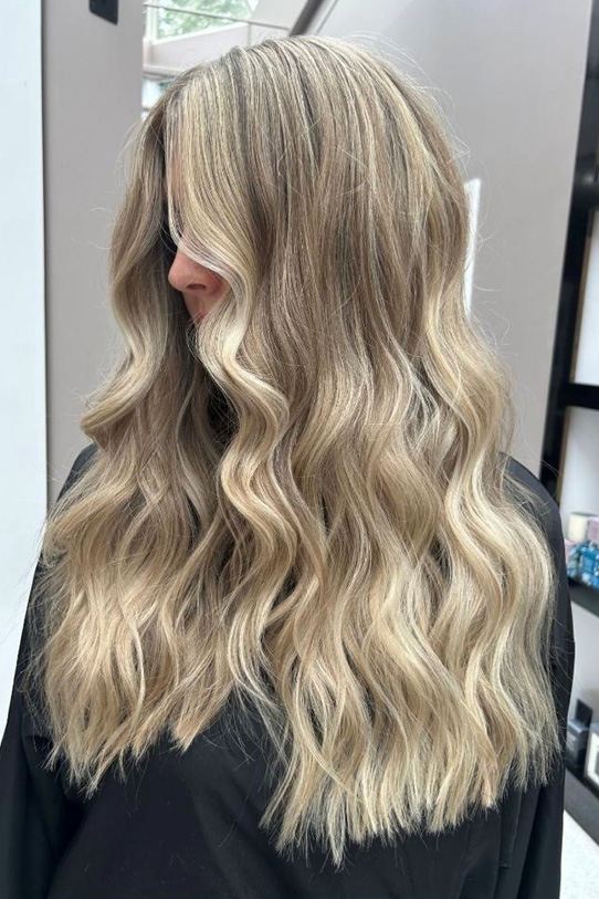 A side profile image of a client's freshly curled, blonde hair